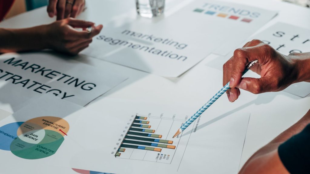 Team working on marketing strategy using data charts and papers in an office meeting. — "A Guide to Effective Content Marketi