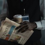 Close-up of a journalist holding a newspaper and coffee cup, conveying press and media concept. — From Chaos to Clarity: The