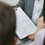 Close-up of professionals discussing a legal contract during a business meeting. — "How to Avoid Common Mistakes During Marke
