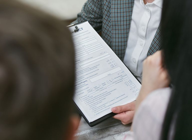 Close-up of professionals discussing a legal contract during a business meeting. — "How to Avoid Common Mistakes During Marke