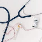 Flat lay of medical tools including stethoscope and measuring tape on a white background. — The Benefits of Using Hair, Skin,