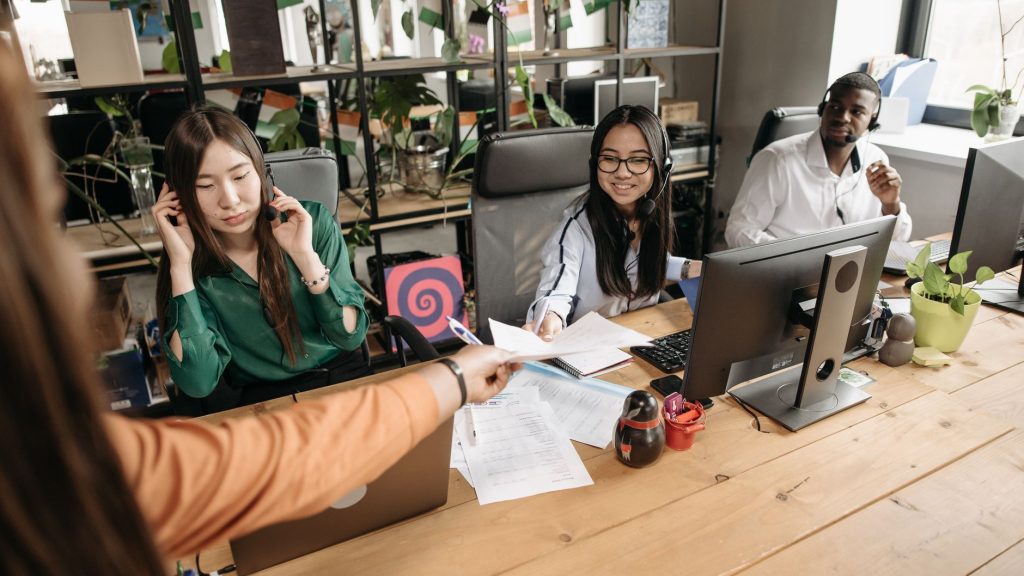 Diverse call center team collaborating at a modern workspace, showcasing teamwork and communication. — The Pros and Cons of F