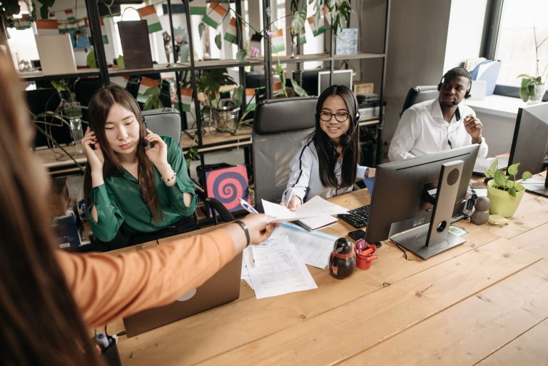 Diverse call center team collaborating at a modern workspace, showcasing teamwork and communication. — The Pros and Cons of F